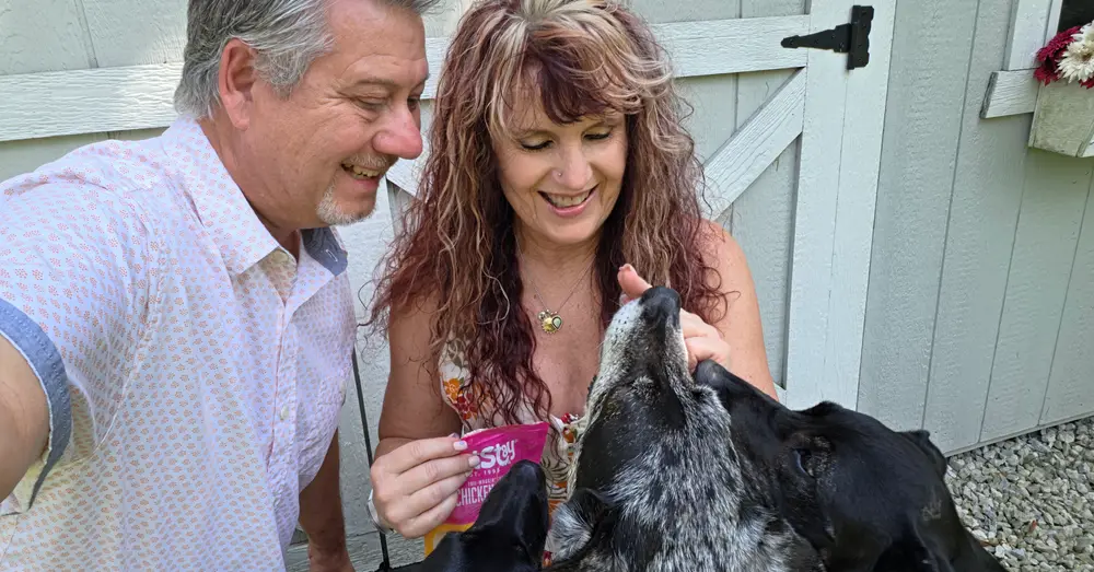 One of Jodi’s dogs eagerly takes a chicken chip treat